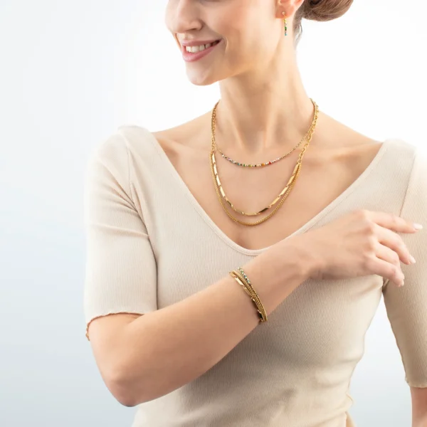 Modell trägt das Armband "Golden Whisper Rainbow" von Coeur de Lion am Handgelenk – stilvoll kombiniert für einen eleganten Look.