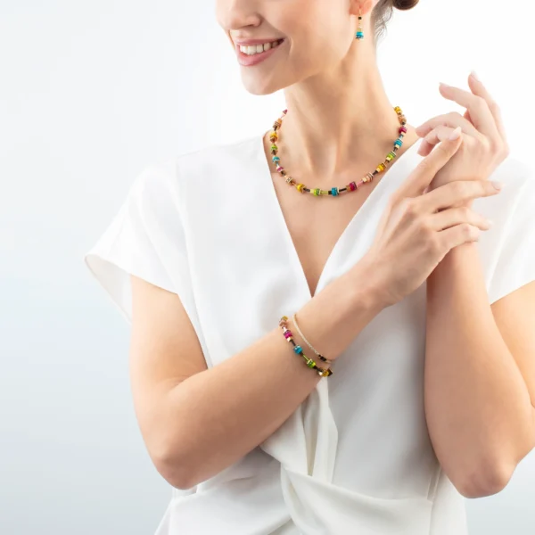 Modell trägt das Armband „Boho Sunset Cube Rainbow“ von Coeur de Lion am Handgelenk – stilvoll kombiniert zu moderner Kleidung.