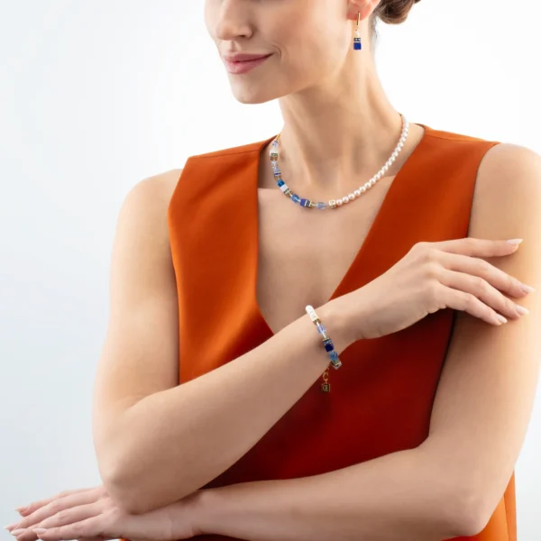 Model trägt elegantes Armband und Collier aus der GEOCUBE® Precious Fusion Pearls Kollektion in Blau – hochwertiger Schmuck von COEUR DE LION für besondere Anlässe.
