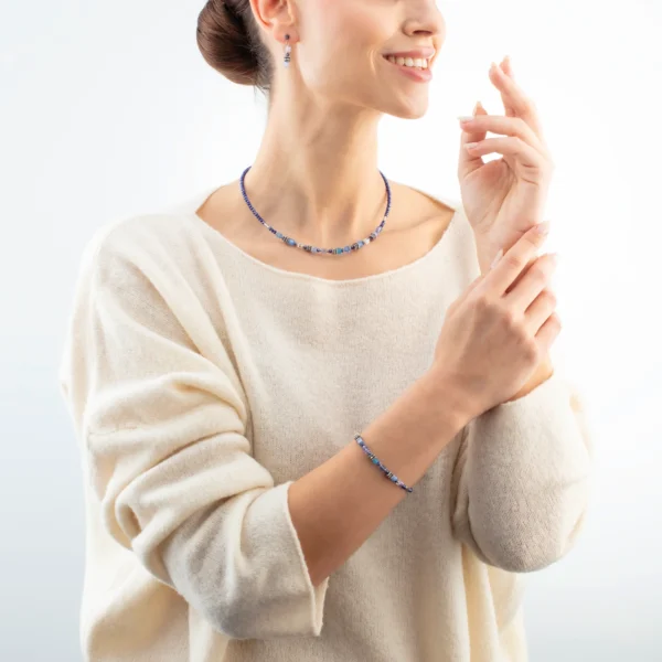 Modell trägt das blaue Armband Mini Cubes von Coeur de Lion – stilvoll kombiniert, modernes Design, hochwertiger Damenschmuck.