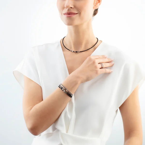Modell trägt das stilvolle „Joyful Colours Update“ Armband von Coeur de Lion in Silber und Schwarz am Handgelenk, elegant kombiniert zu moderner Kleidung.