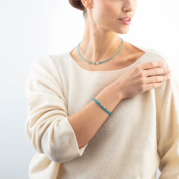 Modell trägt das Joyful Colours Update Armband gold-türkis von Coeur de Lion – stilvolle Schmuckpräsentation am Handgelenk.